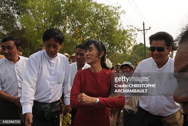 Myanmar opposition leader Aung San Suu Kyi smiles as she leaves after visiting a polling station in the constituency where she stands as a candidate...
