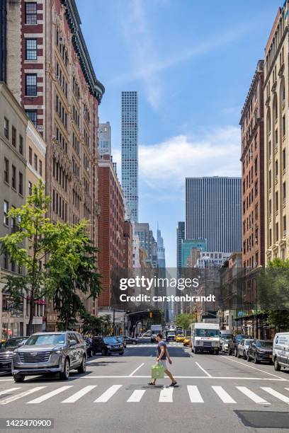 blick auf die madison avenue mit einem mann in einem zebrastreifen - madison avenue stock-fotos und bilder