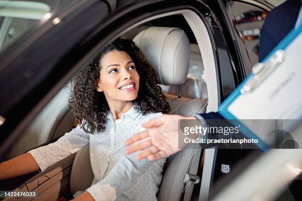 car dealer is presenting new car to a customer - luxury cars show stock pictures, royalty-free photos & images