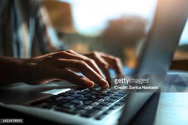 primer plano de las manos en el teclado de una computadora portátil - hands on fotografías e imágenes de stock