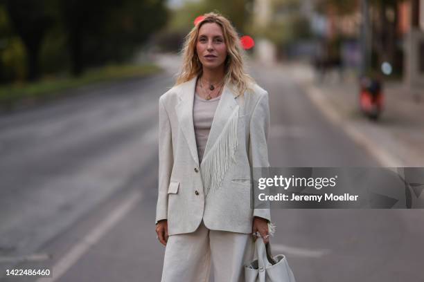 Cloudy Zakrocki is seen wearing beige fringed oversize blazer, beige tank top, matching beige suit pants, beige leather bag from Polène Paris, before...