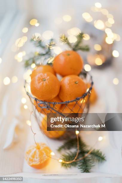 basket with tangerines and christmas lights garland - spruce twig stock pictures, royalty-free photos & images