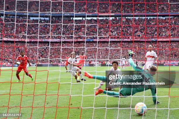 Mathys Tel of Bayern Munich scores their team's first goal past Florian Muller of VfB Stuttgart during the Bundesliga match between FC Bayern...