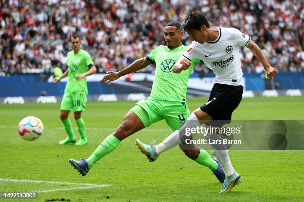 Daichi Kamada of Eintracht Frankfurt shoots while under pressure from Maxence Lacroix of VfL Wolfsburg during the Bundesliga match between Eintracht...