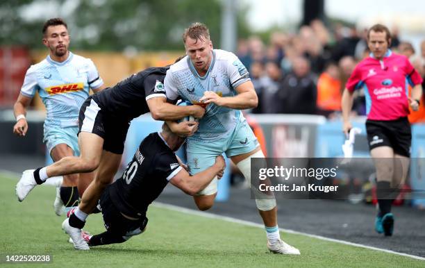 Alex Dombrandt of Harlequins is tackled by Brett Connon and Adam Radwan of Newcastle Falcons during the Gallagher Premiership Rugby match between...