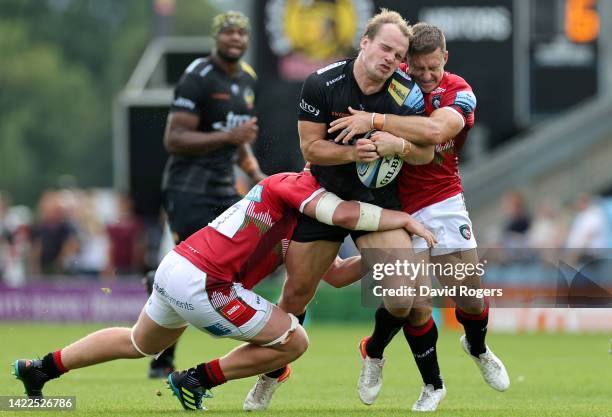 Stu Townsend of Exeter Chiefs is tackled by Tommy Reffell and Jimmy Gopperth of Leicester Tigers during the Gallagher Premiership Rugby match between...