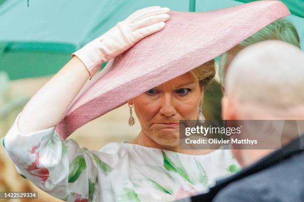 Queen Mathilde of Belgium protects her hat from the strong wind around the Cathedral of St. Michael and St. Gudula after the wedding of Princess...