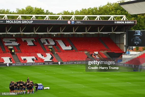 Bristol Bears huddle as LED boards inside the stadium display a tribute to Her Majesty Queen Elizabeth II, who died away at Balmoral Castle on...