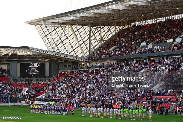Players, fans and officials take part in a minute silence as an LED board inside the stadium displays a tribute to Her Majesty Queen Elizabeth II who...