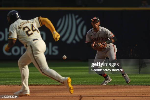 Thairo Estrada of the San Francisco Giants fields a ground ball as Andrew McCutchen of the Milwaukee Brewers runs to second base during game one of a...