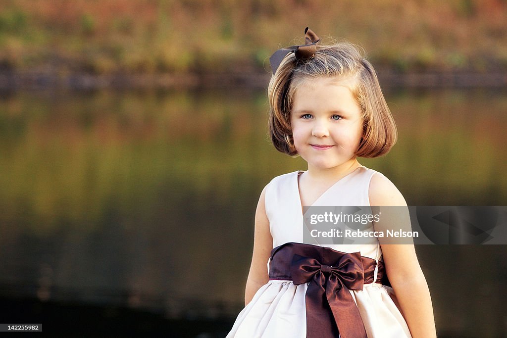 Girl in fancy dress in front of river