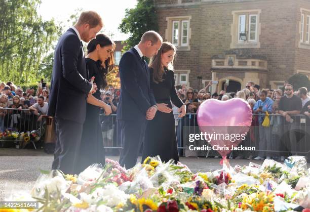 Prince Harry, Duke of Sussex, Meghan, Duchess of Sussex, Prince William, Prince of Wales and Catherine, Princess of Wales look at floral tributes...