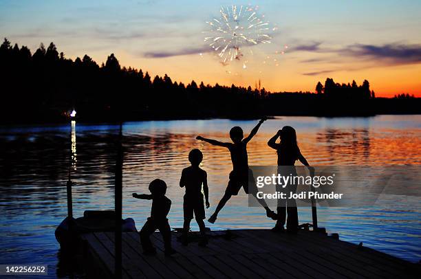 silhouettes of kids on dock - blaine lake stock pictures, royalty-free photos & images