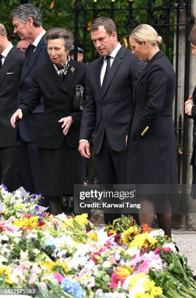 Anne, Princess Royal, Peter Phillips and Zara Phillips view the flowers left by mourners outside Balmoral Castle on September 10, 2022 in Aberdeen,...