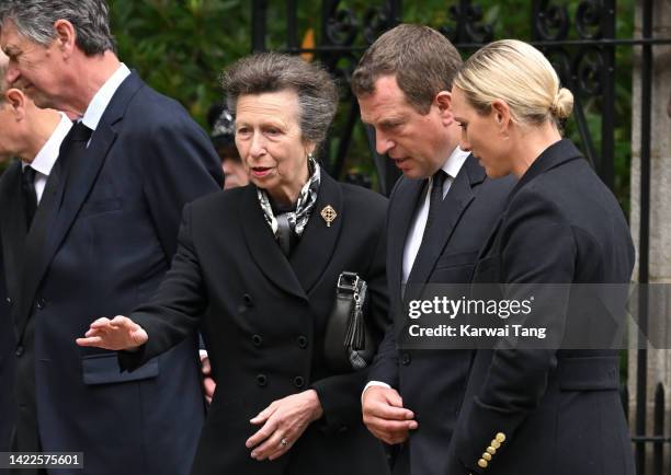 Anne, Princess Royal, Peter Phillips and Zara Phillips view the flowers left by mourners outside Balmoral Castle on September 10, 2022 in Aberdeen,...