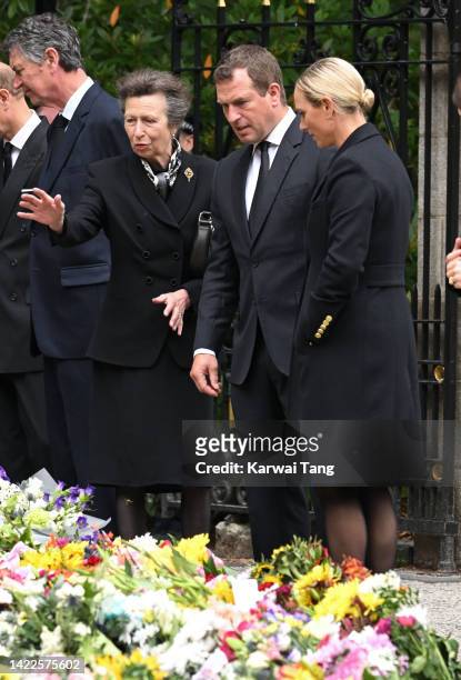Anne, Princess Royal, Peter Phillips and Zara Phillips view the flowers left by mourners outside Balmoral Castle on September 10, 2022 in Aberdeen,...