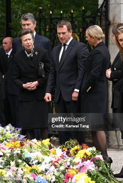 Timothy Laurence, Anne, Princess Royal, Peter Phillips and Zara Phillips view the flowers left by mourners outside Balmoral Castle on September 10,...