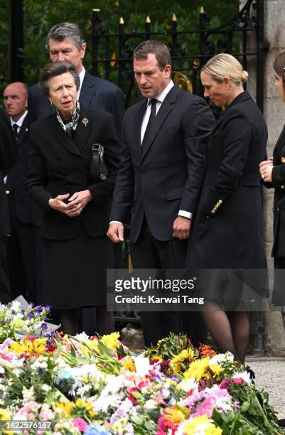 Timothy Laurence, Anne, Princess Royal, Peter Phillips and Zara Phillips view the flowers left by mourners outside Balmoral Castle on September 10,...