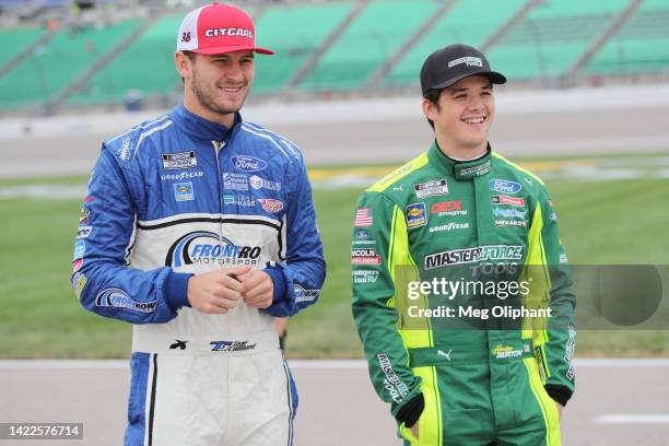 Todd Gilliland, driver of the CITGARD Ford, and Harrison Burton, driver of the Menards/MasterForce Ford, talk on the grid during practice for the...