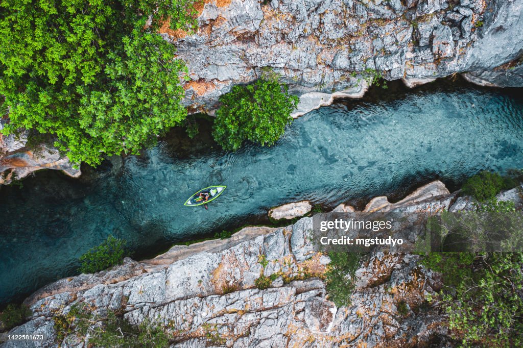 Aerial view of Kayak on river flowing in canyon