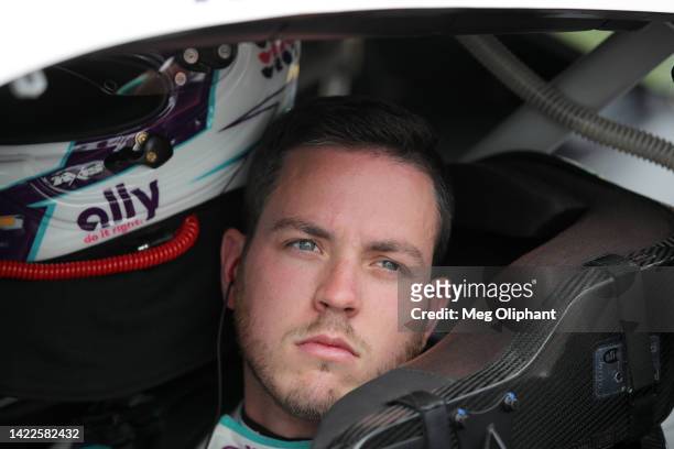 Alex Bowman, driver of the Ally Chevrolet, sits in his car during qualifying for the NASCAR Cup Series Hollywood Casino 400 at Kansas Speedway on...