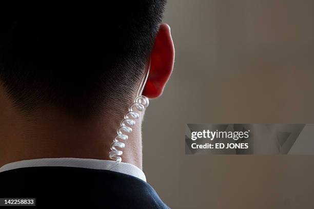 Security guard wears an earpiece as he stands outside a bilateral meeting during the Boao Forum for Asia on the southern Chinese island of Hainan on...