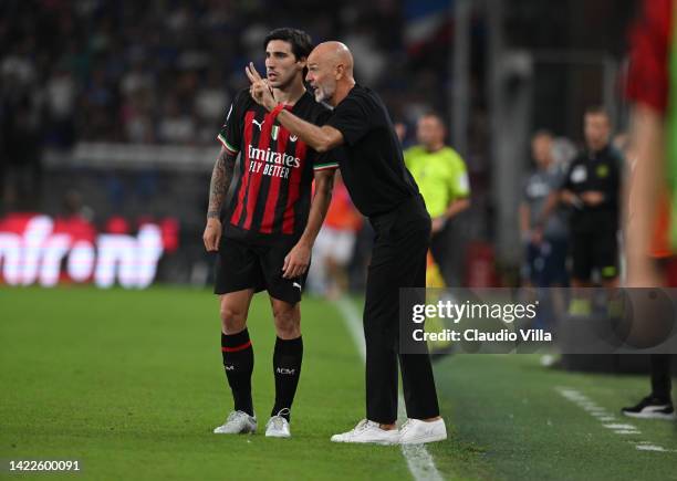 Head coach of AC Milan Stefano Pioli speaks with Sandro Tonal during the Serie A match between UC Sampdoria and AC MIlan at Stadio Luigi Ferraris on...