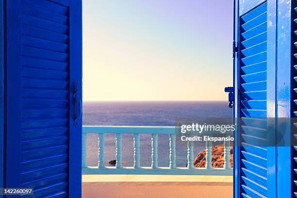 bleu volets de style colonial s'ouvrent sur la mer et du ciel à l'aube - vue dans la mer photos et images de collection