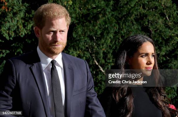 Prince Harry, Duke of Sussex, and Meghan, Duchess of Sussex on the long Walk at Windsor Castle arrive to view flowers and tributes to HM Queen...