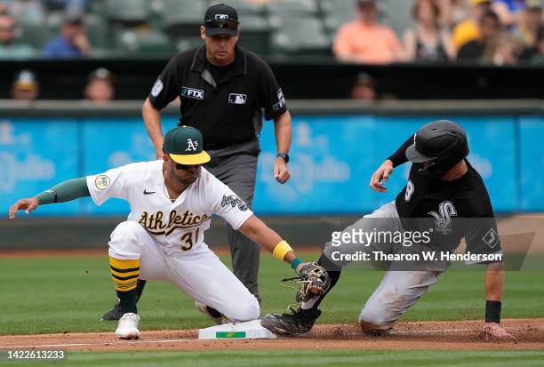 Pollock of the Chicago White Sox steals third base sliding past the tag of Vimael Machin of the Oakland Athletics in the top of the second inning at...
