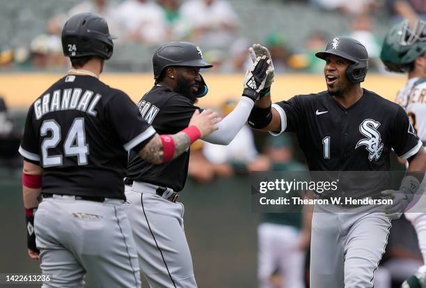 Elvis Andrus of the Chicago White Sox is congratulated by Josh Harrison and Yasmani Grandal after Andrus hit a three-run home run against the Oakland...