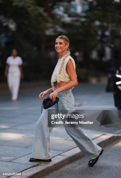 Xenia Adonts seen wearing with pigtail cropped top, denim jeans outside Proenza Schoulerseen during New York Fashion Week on September 09, 2022 in...