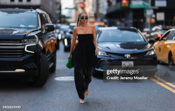 Leonie Hanne is seen wearing a black Proenza Schouler one piece outfit and green faux fur bag outside the Proenza Schouler show during New York...