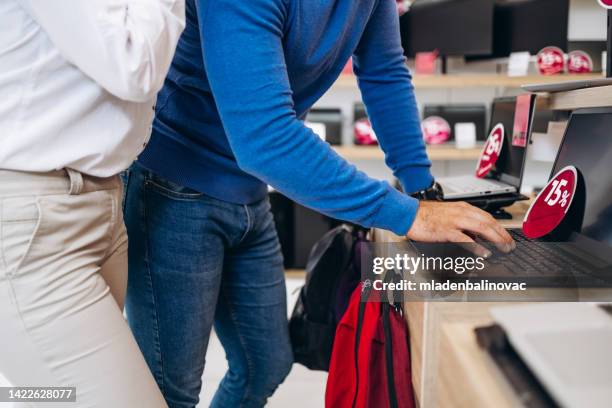 beautiful and happy young couple buying in modern appliances store. - electronic products stockfoto's en -beelden