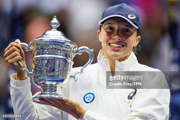 Iga Swiatek of Poland celebrates with the US Open trophy after beating Ons Jabeur of Tunisia in the final of the women's singles at the US Open at...