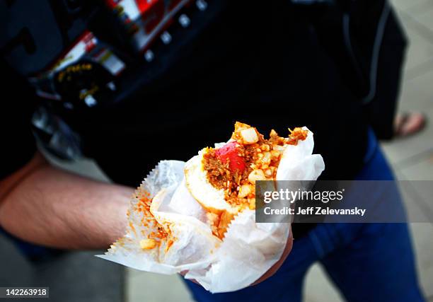 Jason Black pauses while eating a Martinsville Slider hot dog prior to the NASCAR Sprint Cup Series Goody's Fast Relief 500 at Martinsville Speedway...