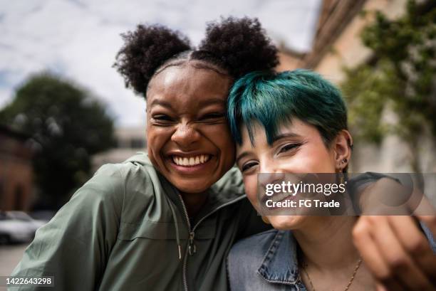 portrait of friends embracing in the street - teenagers stockfoto's en -beelden