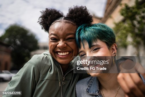 Portrait of friends embracing in the street Portrait of friends embracing in the street