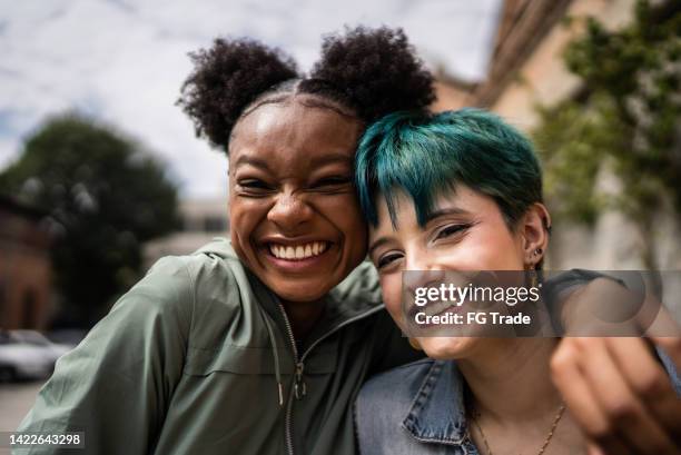 portrait of friends embracing in the street - diversification imagens e fotografias de stock