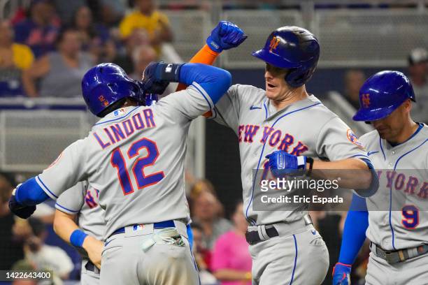 Mark Canha of the New York Mets is congratulated by Francisco Lindor after hitting a grand slam in the fourth inning against the Miami Marlins at...