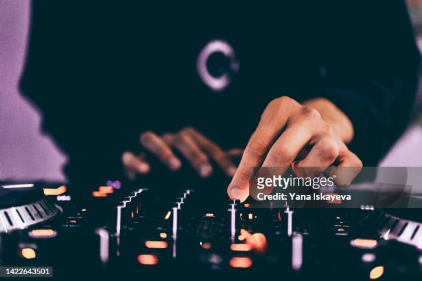 american dj working with sound, spinning turntable records at a night club party - dj fotografías e imágenes de stock