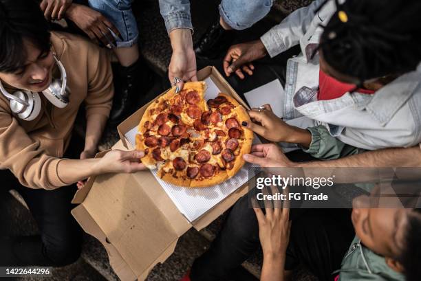 hands picking pizza slices - pepperoni pizza overhead stock pictures, royalty-free photos & images