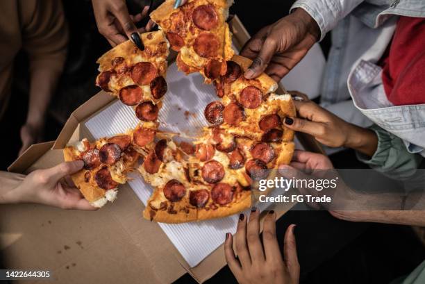 ピザのスライスを摘む手 - pizza share ストックフォトと画像