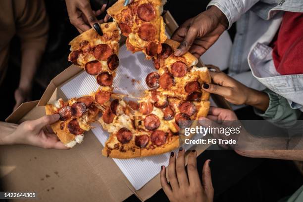 hands picking pizza slices - pizza-de-pepperoni imagens e fotografias de stock