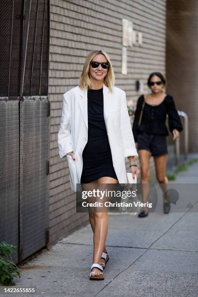 Lisa Aiken wearing white blazer, black dress, creme white bag outside Altuzarra on September 10, 2022 in New York City.