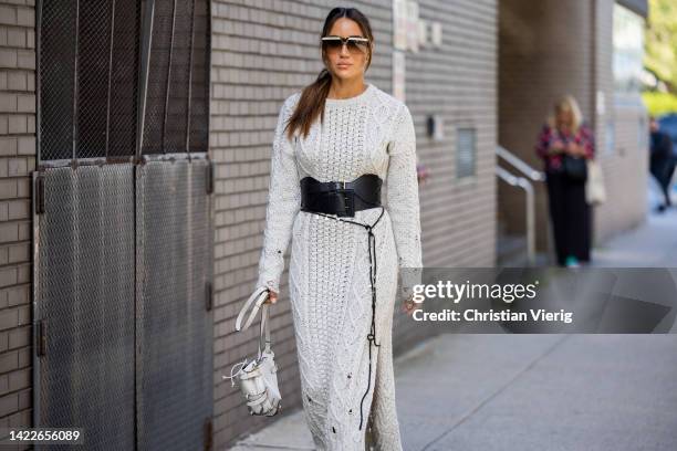 Tamara Kalinic wearing outside white knit dress, black belt, white bag, black ankle boots on September 10, 2022 in New York City.