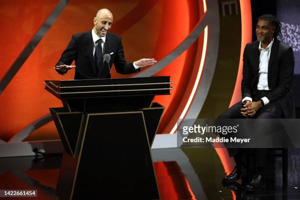 Naismith Memorial Basketball Hall of Fame Class of 2022 enshrinee Manu Ginobili gives a speech as Tim Duncan looks on during the 2022 Basketball Hall...