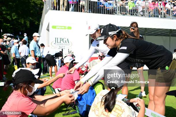 Mone Inami and Momoko Osato of Japan present autographed stickers to kids on the 1st tee during the final round of the JLPGA Championship Konica...