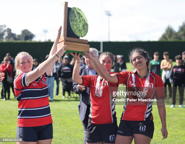 Captains Eliza Dalzell of Christchurch Girls High School with Mia Maraku and Leiana Marshall-Barton of Manukura raise the girls trophy after the...
