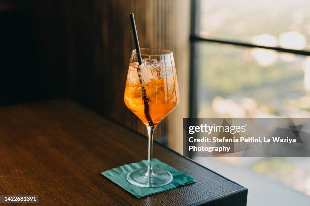 aperol in a drinking glass - rietje stockfoto's en -beelden